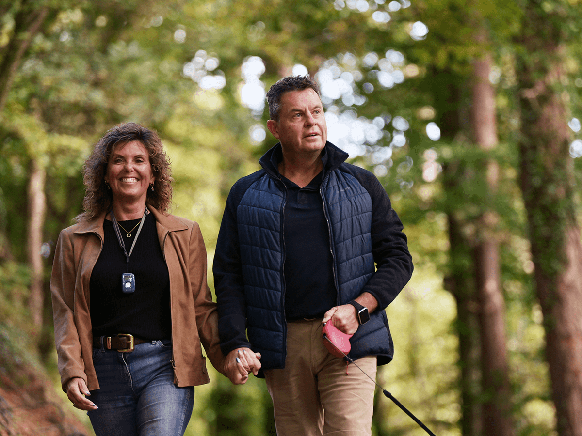An older couple walking their dog wearing delta TEC