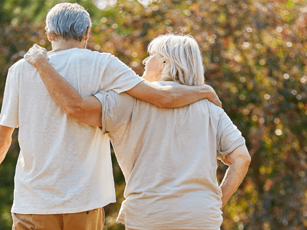Two older people walking together