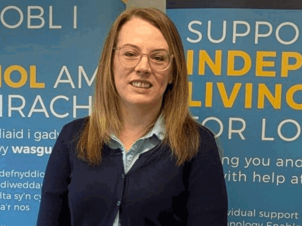 Female community wellbeing officer standing outside living well centre in Carmarthen