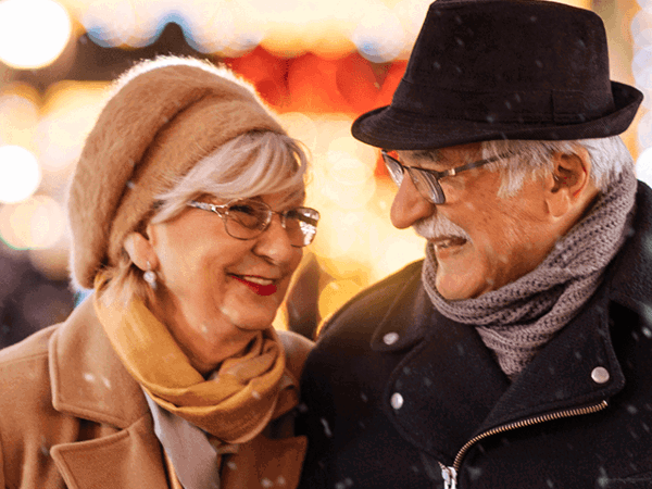 Two people outside in the cold, wearing hats and scarfs in the winter