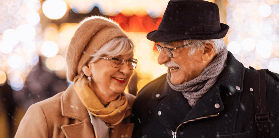 Two people outside in the cold, wearing hats and scarfs in the winter