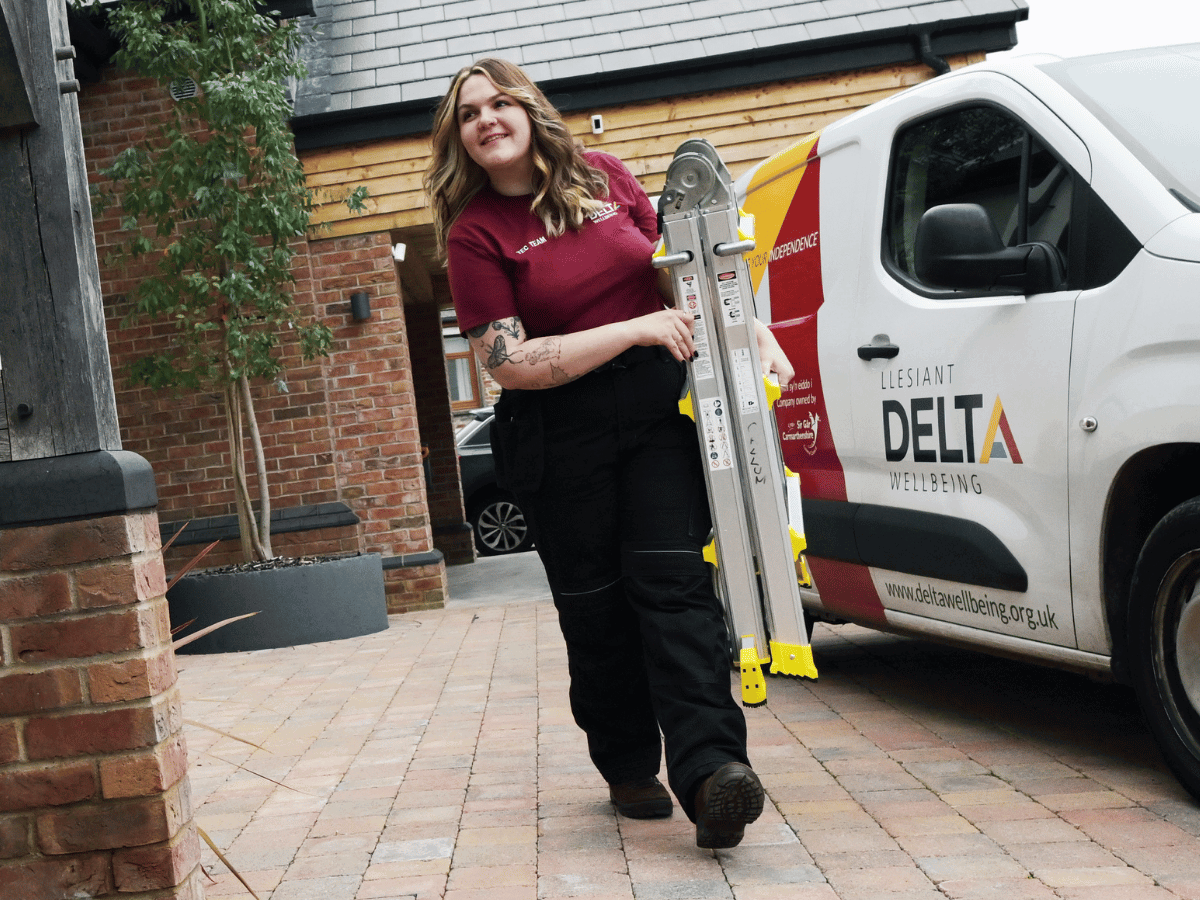 Delta staff member holding a ladder outside a customers home