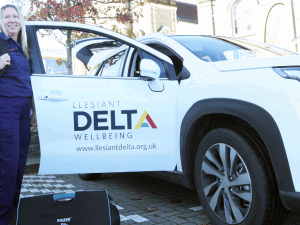 Female Response Officer standing by Delta Wellbeing car